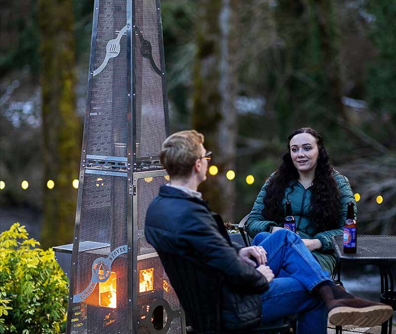 Homeowner using a Timber Stoves wood pellet heater on a winter patio.